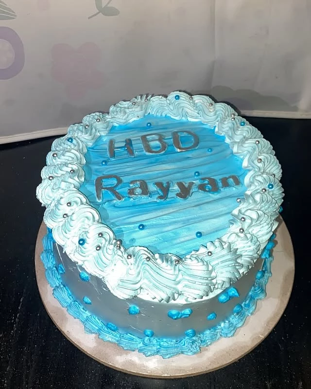 HBD Rayyan birthday cake with blue theme and beautiful decorations for celebration - Blue Theme Cakes Karachi By Whisk And Sift